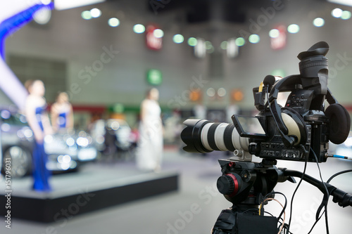 Covering an event on stage with a video camera.