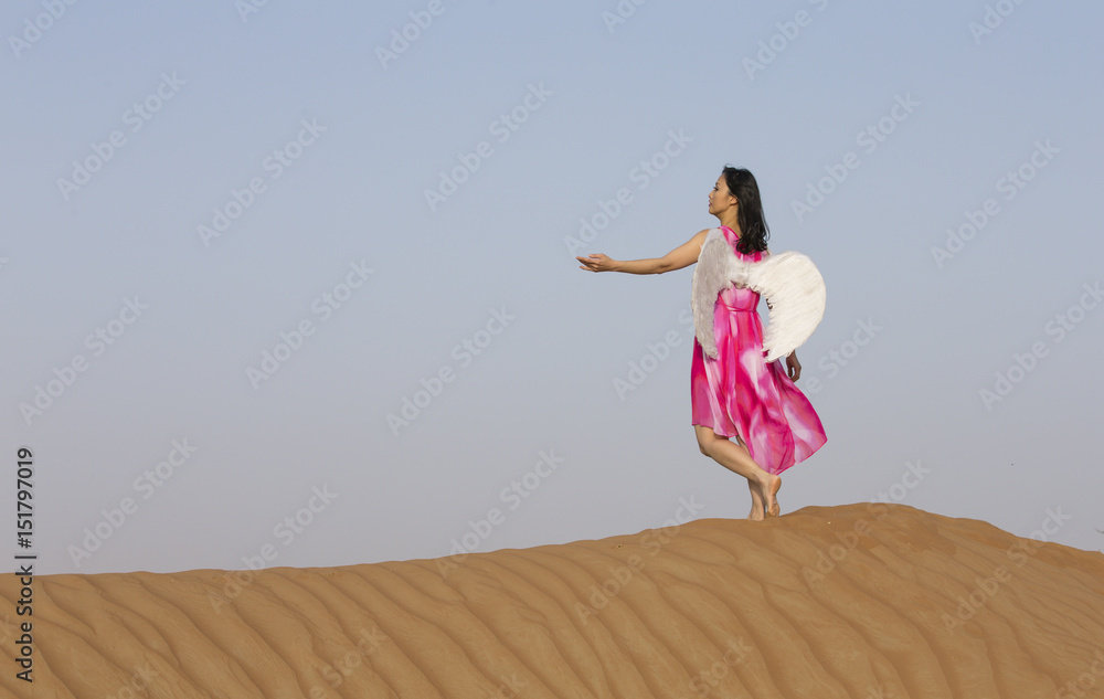 young woman with angel wings in a desert young woman with angel wings in a desert