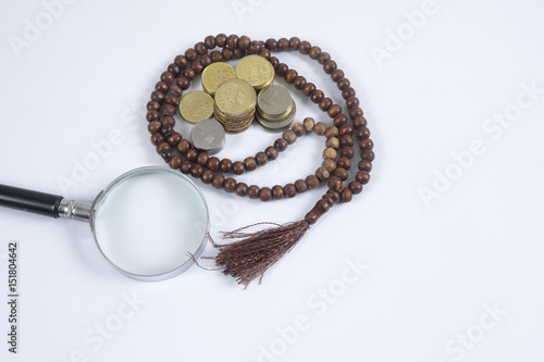 Rosary and coins on white background. Islamic business concept.