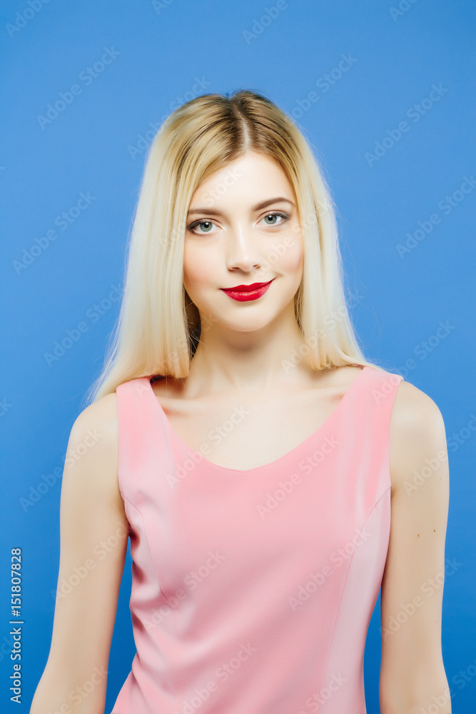 Amazing Blond-haired Woman with Professional Makeup in Studio. Portrait of Beautiful Girl on Blue Background. Amazing Blond-haired Woman with Professional Makeup in Studio. Portrait of Beautiful Girl on Blue Background.