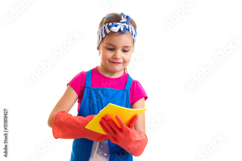 Girl in apron and gloves holding spray and duster