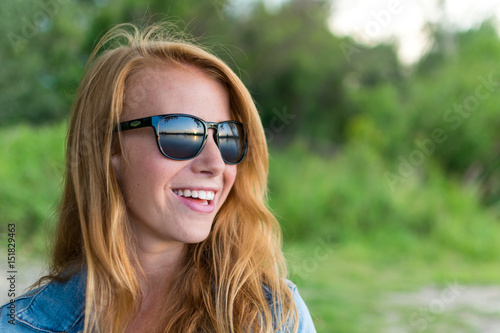 red haired girl / female with sunglasses looking at sunset