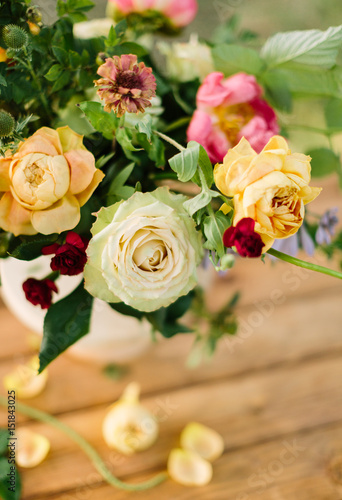 bouquet  holiday flower  gift and floral arrangement concept - top view of a delightful summer fresh white and yellow roses and pink peonies  decoration of festive bouquet on wooden table background
