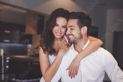 Young successful couple smiling, woman embrace man indoors