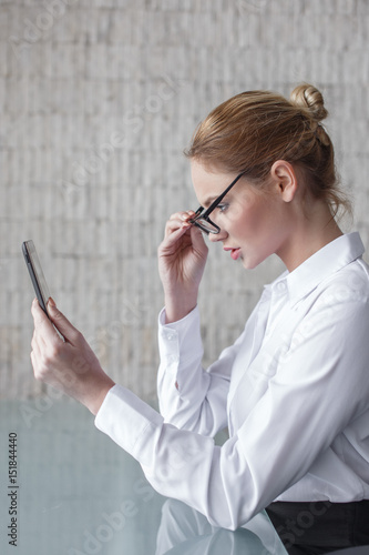 Young smart businesswoman reading bad news on tablet