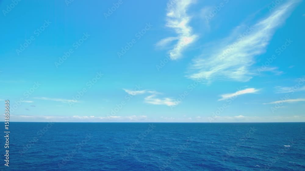 Moving Blue Oceanscape from Cruising Ship at Sea Sailing on Exotic Water with White Clouds on the Horizon during Idyllic Weather (Lower Third) Moving Blue Oceanscape from Cruising Ship at Sea Sailing on Exotic Water with White Clouds on the Horizon during Idyllic Weather (Lower Third)