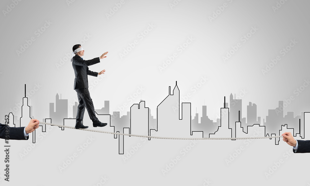 Business concept of risk support and assistance with man balancing on rope Business concept of risk support and assistance with man balancing on rope