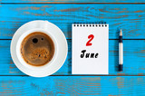 June 2nd. Day of the month 2 , everyday calendar near morning coffee cup at blue wooden background. Summer concept, Top view