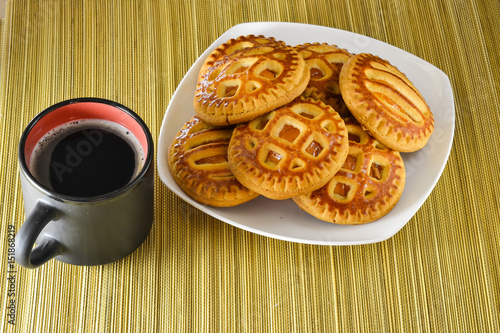 Cookies on a plate and a cup of black coffee. photo