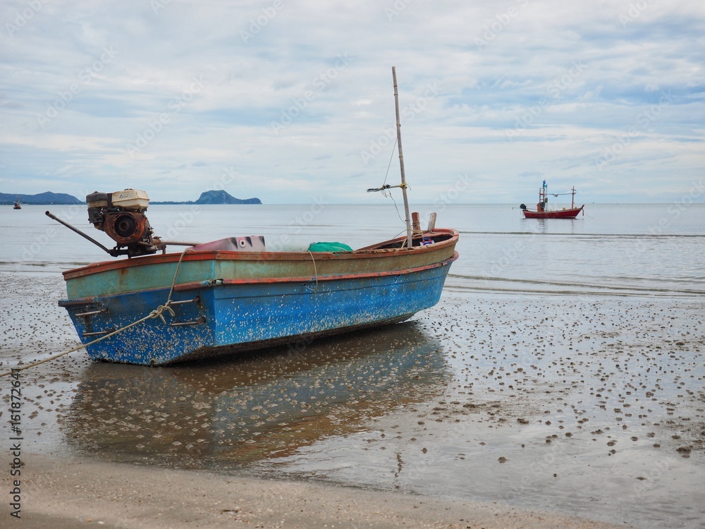Fishing boat parking on sand beach with beautiful clam sea background on cloudy day, dolphin bay, prachuap khiri khan, Thailand Fishing boat parking on sand beach with beautiful clam sea background on cloudy day, dolphin bay, prachuap khiri khan, Thailand