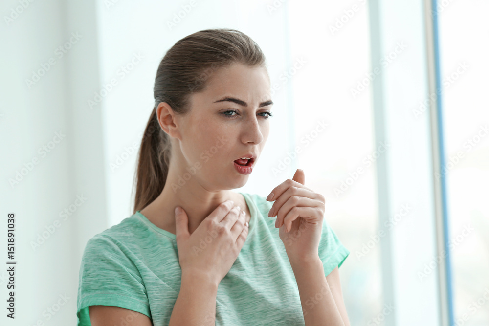 Young woman suffering from cough at home Young woman suffering from cough at home