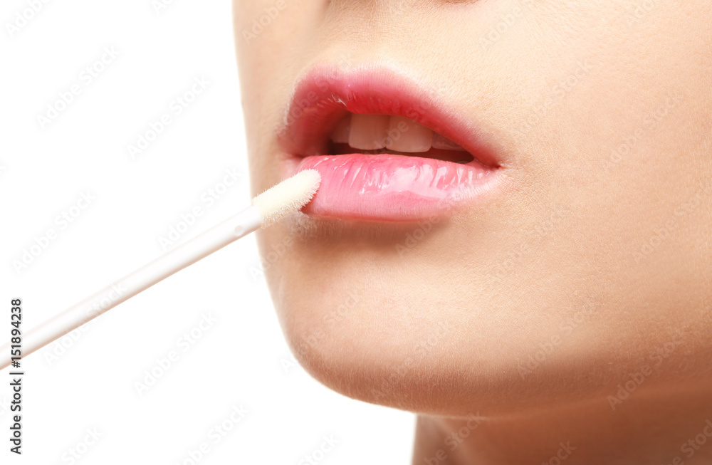 Obraz premium Beautiful young woman applying lipstick on white background, closeup