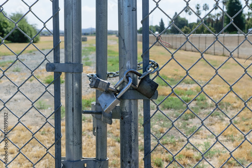 Three locks secure gate on fence
