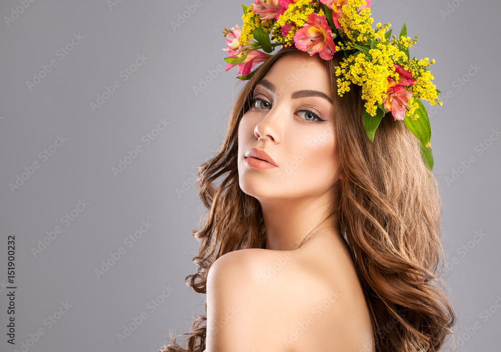Glamour portrait of very beautiful young woman with summer wreath on the head. Professional make up. Studio shoot.