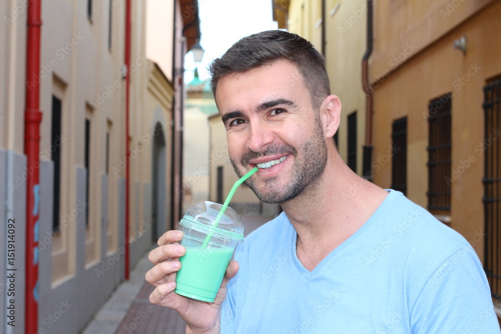 Cute man drinking a shake outdoors Cute man drinking a shake outdoors