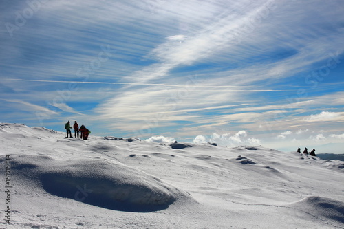 A pack of hikers walking down from Matagalls peak summit on a winter sunny day, Montseny mountains, Barcelona. photo