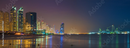 Dubai -  The nightly skyline panorama of Marina towers and worlds largest Ferris wheel under construction.