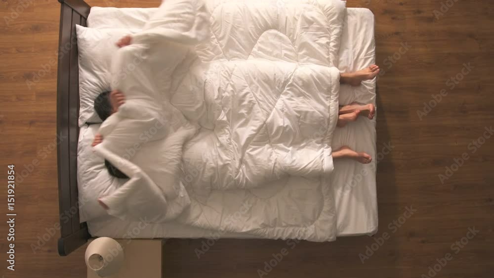 The happy couple have a sex under duvet. view from above Stock Video