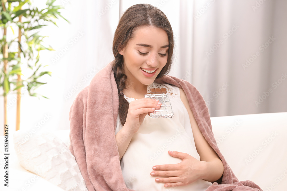 Young pregnant woman eating chocolate at home Young pregnant woman eating chocolate at home
