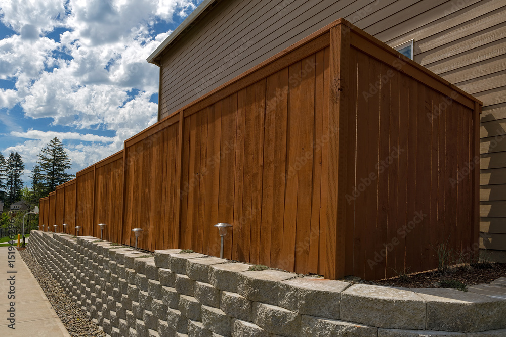 Fototapeta premium Wood Fence and Cement Blocks Retaining Wall