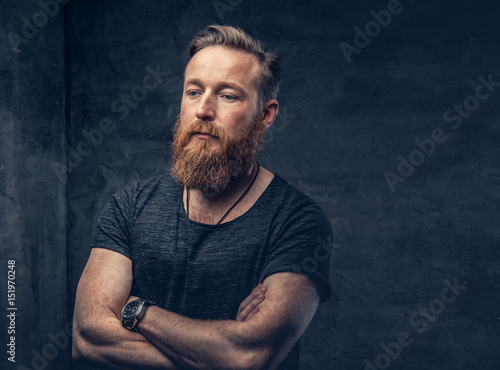 Bearded male with crossed arms.