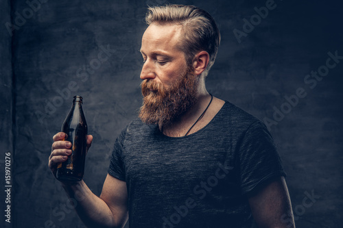 A man holds beer bottle.