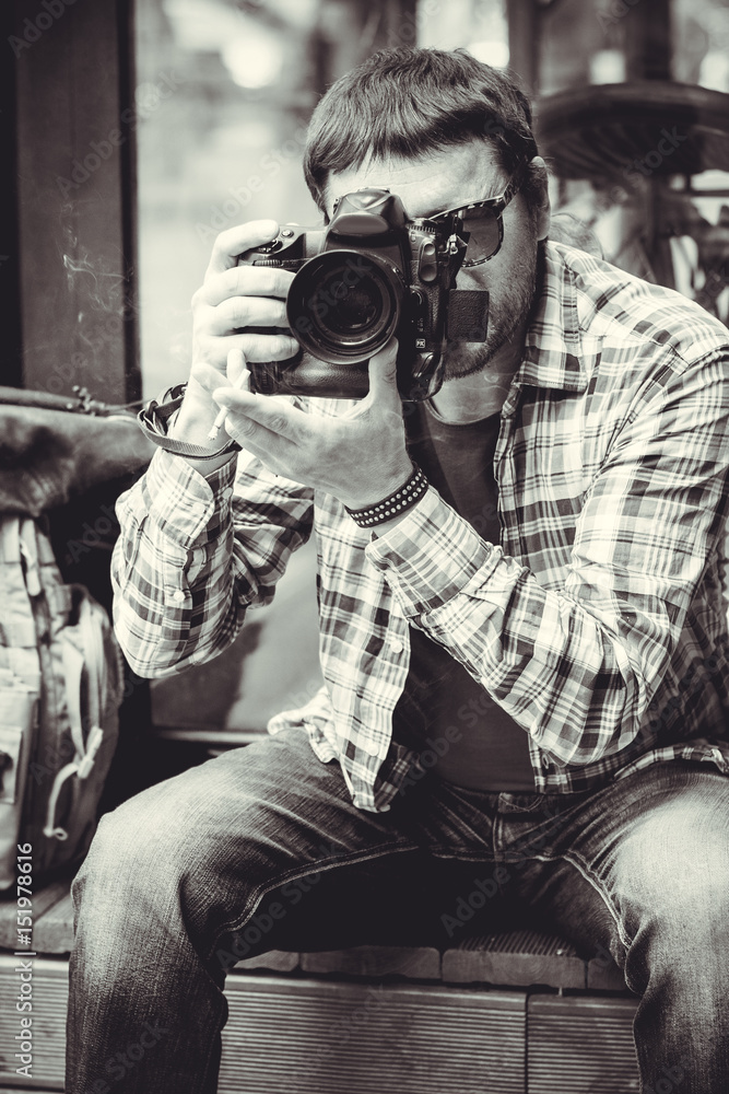 A man hipster style with a camera in center of Europe. Human have a hobby photography A man hipster style with a camera in center of Europe. Human have a hobby photography