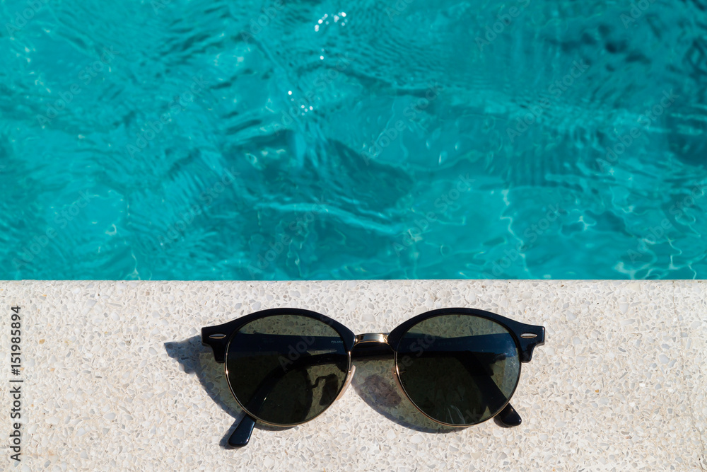 Sunglasses the side of swimming pool, summer travel concept