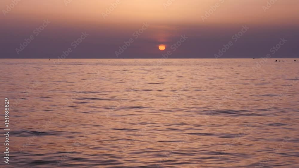 Sunset on the beach - Tranquil idyllic scene of a purple sunset over the sea, slowly rolling waves Sunset on the beach - Tranquil idyllic scene of a purple sunset over the sea, slowly rolling waves