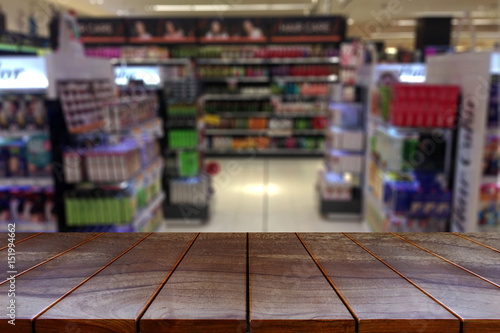 Empty wooden table space platform and blurred Supermarket aisle with product shelves background for product display