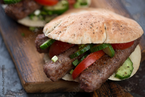 Close-up of pita bread filled with barbecued cevapcici or skinless beef sausages, shallow depth of field, horizontal shot