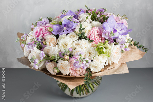 luxurious and elegant bouquet of roses and Other colors flowers on wooden gray background, copy space.