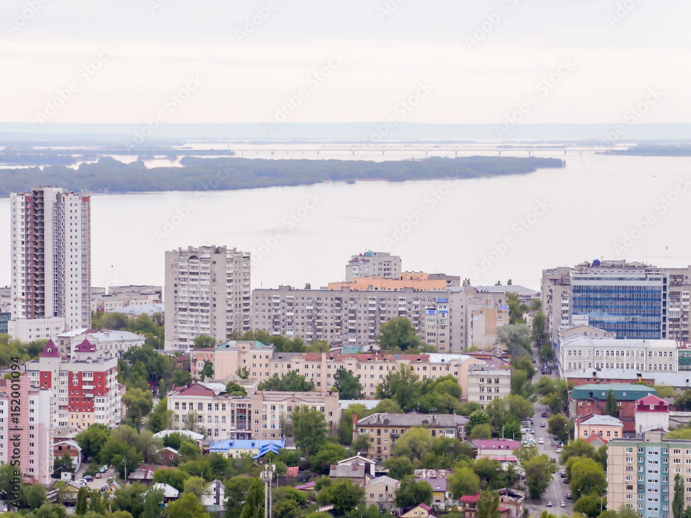 The city's skyline. The Russian province of Saratov. High-rise residential buildings, the Volga river and the railway bridge on the horizon