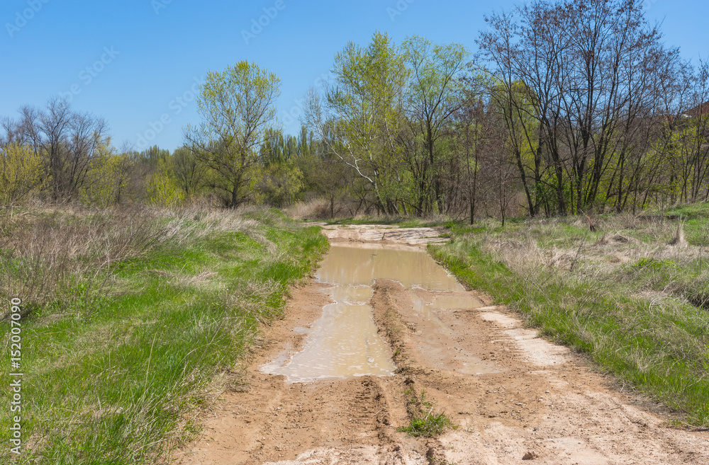 Spring landscape with clay dirty road in rural Ukrainian area