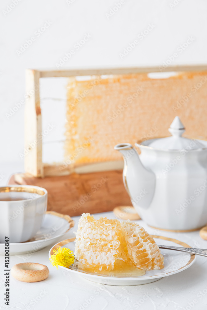 Cups of tea with honeycomb and bagels on a white background Cups of tea with honeycomb and bagels on a white background