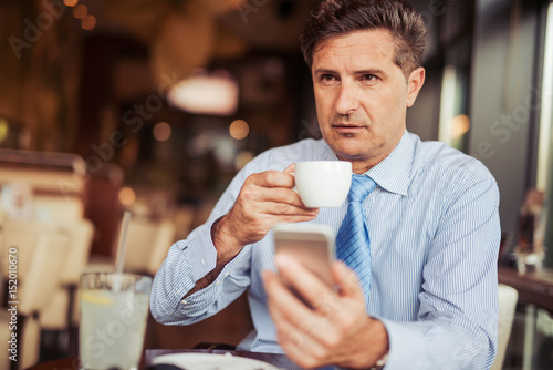 Attractive mid adult man drinking coffee in cafe