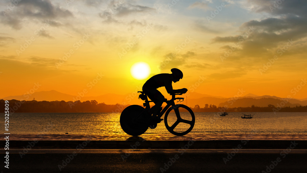 Fototapeta premium Man cycling at beach evening time