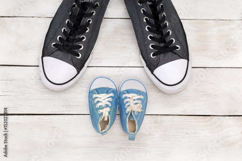 Wallpaper Mural Daddy's boots and baby's shoes, fathers day concept. flat lay Torontodigital.ca