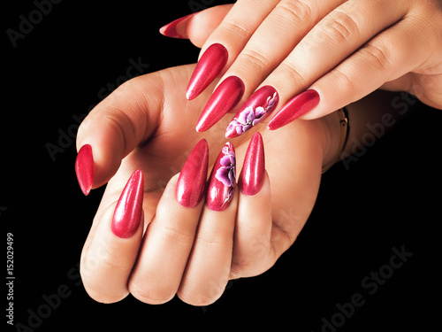 Red nails and floral deign, on black background.