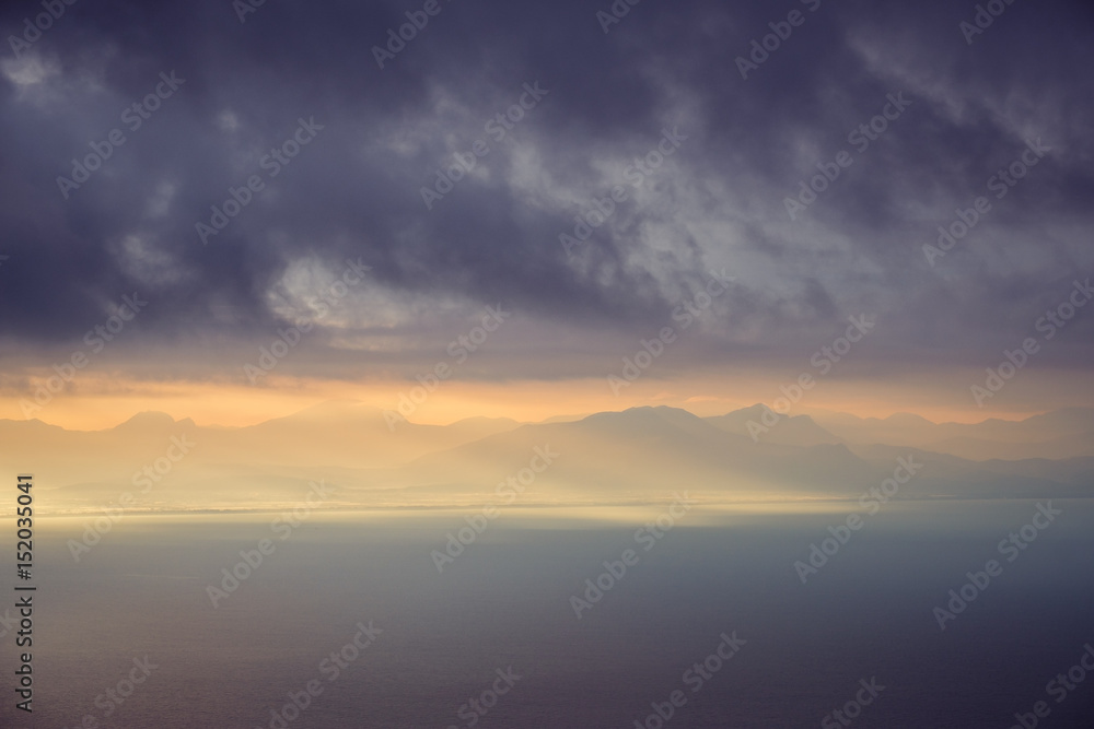 Fototapeta premium Dramatic landscape view of sunrise over mountains and the ocean