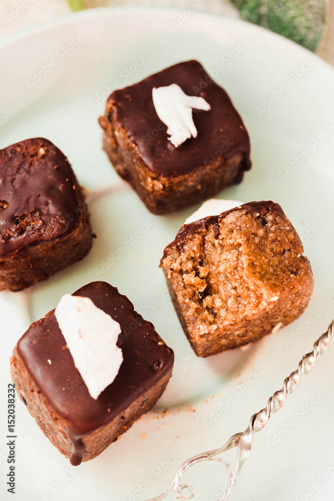 Raw chocolate candy with nuts and coconut, healthy vegan dessert Raw chocolate candy with nuts and coconut, healthy vegan dessert
