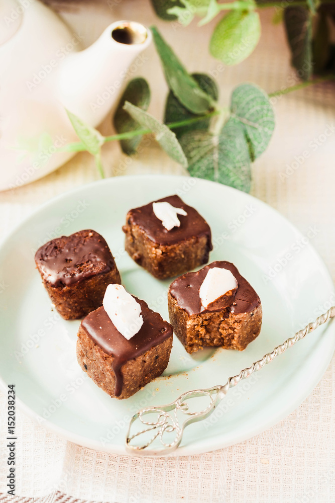 Raw chocolate candy with nuts and coconut, healthy vegan dessert Raw chocolate candy with nuts and coconut, healthy vegan dessert