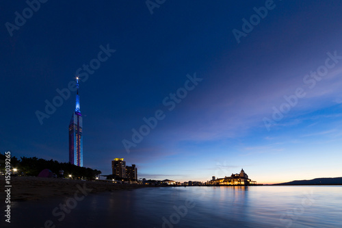 Illuminated Fukuoka tower and ocean in twilight
