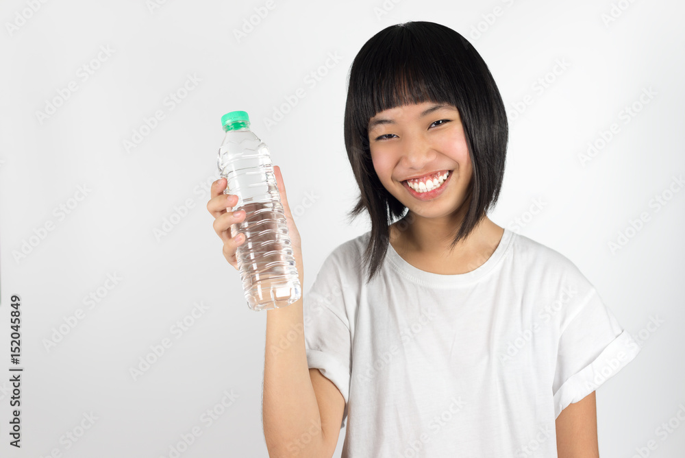 Young beautiful asian teenage girl holding bottle of water isolated against white background Young beautiful asian teenage girl holding bottle of water isolated against white background