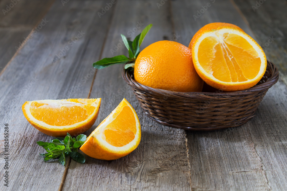 Whole and cut oranges with mint leaves Whole and cut oranges with mint leaves