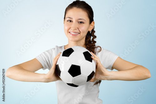 young woman holding soccer ball on her hand