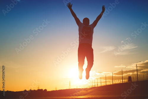 Silhouette of man jumping on sunset background