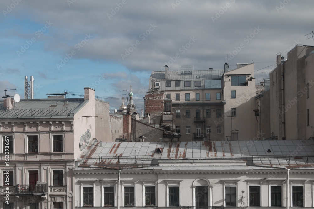 Obraz premium Piece of urban roofs against sky and clouds, Russia, Saint Petersburg.