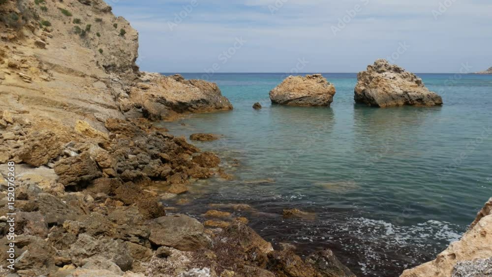 Rocky coast with clear water and large rocks in the background Rocky coast with clear water and large rocks in the background