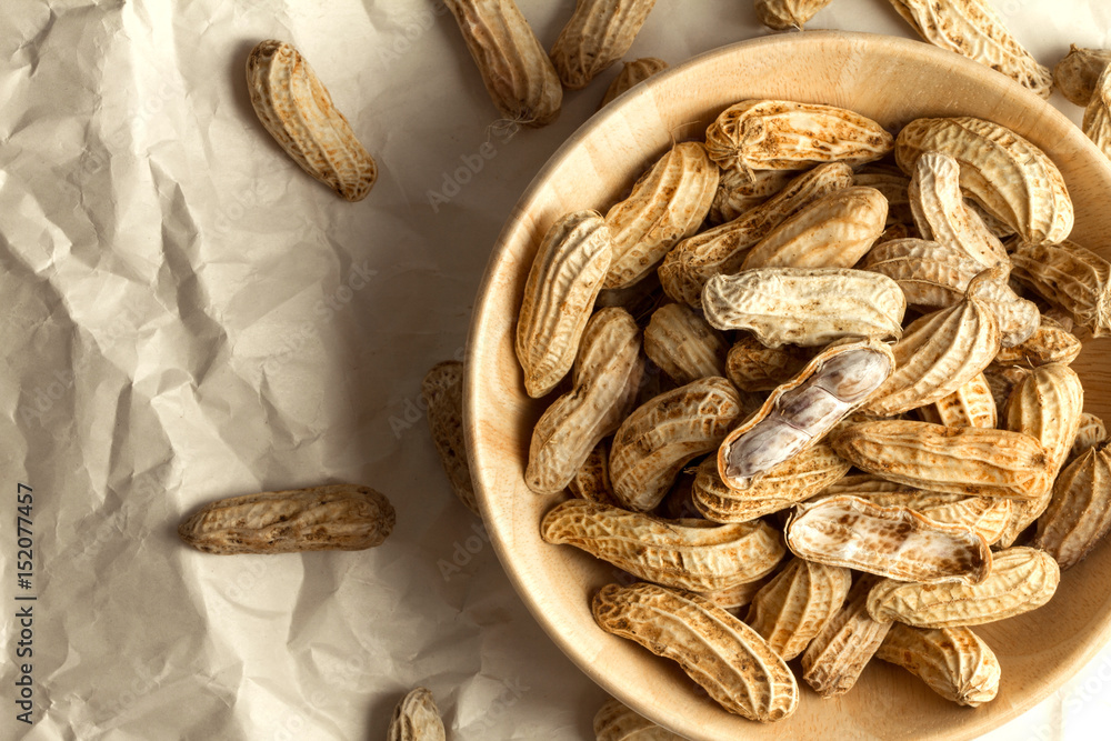 boiled peanuts in wooden cup on crumpled paper boiled peanuts in wooden cup on crumpled paper